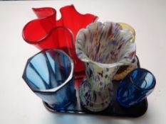 A tray containing 20th century coloured glassware to include studio glass vase, envelope vase,