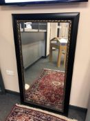 A contemporary black framed mirror 79 x 140 cm