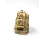 A carved Chinese bone netsuke - Gentleman holding a club