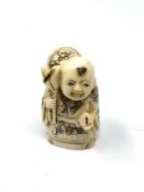 A carved Chinese bone netsuke - Gentleman with sack and fruit