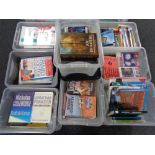 A pallet containing nine plastic storage boxes with lids containing books,