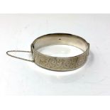 A hinged silver bangle with engine-turned decoration CONDITION REPORT: 46 grams