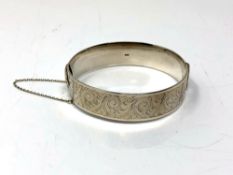 A hinged silver bangle with engine-turned decoration CONDITION REPORT: 46 grams