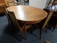 A 20th century G-Plan teak oval extending dining table together with four chairs upholstered in