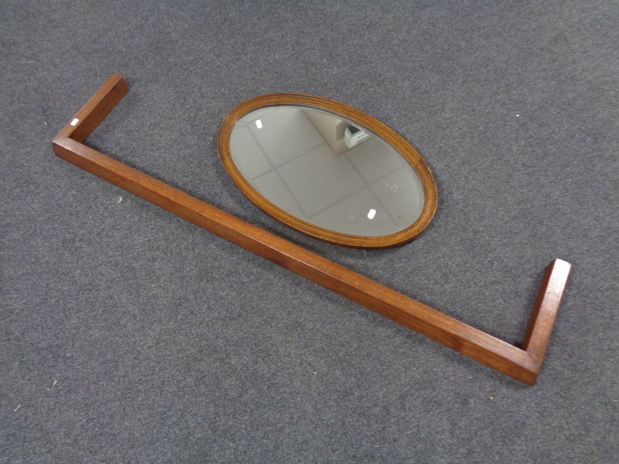 An Edwardian oval framed bevel edged mirror together with a wooden fire curb