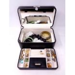 A leather jewellery box containing a quantity of costume jewellery to include brooches, earrings,