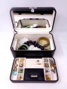 A leather jewellery box containing a quantity of costume jewellery to include brooches, earrings,