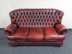 A Chesterfield red buttoned leather high back three seater settee with matching armchair