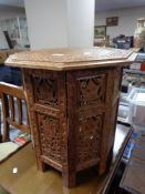 A heavily carved Anglo-Indian octagonal folding table with brass inlay