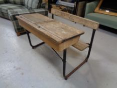 A double school desk with bench on metal frame