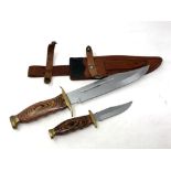 A Bowie knife with brass hilt with matching smaller knife in leather sheath