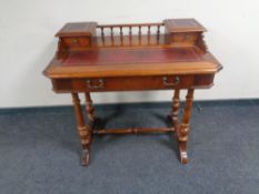 A Victorian style writing table with leather inset panels