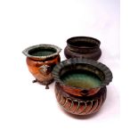 Two antique copper plant pots, one on raised feet,