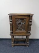 An early 20th century profusely carved cabinet on raised legs.