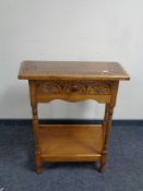 A 20th century carved oak two tier hall table fitted a drawer