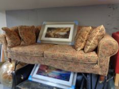 A Victorian style low backed settee in tapestry fabric with six cushions