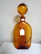 A mid 20th century Blenko amber glass decanter with embossed flower decoration