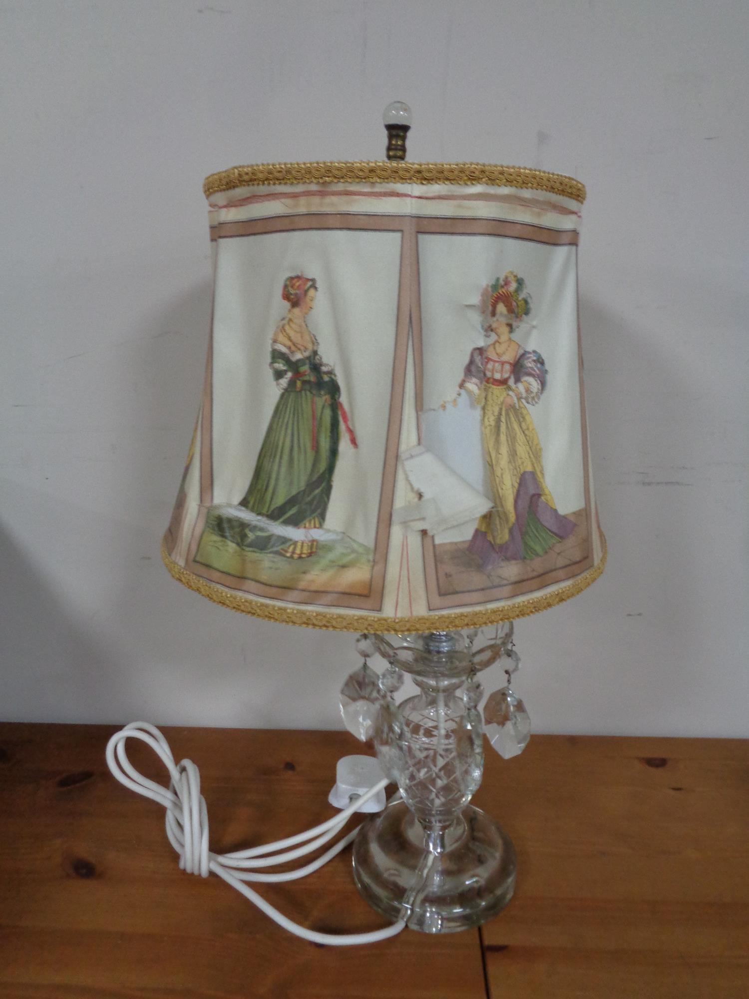 A cut glass table lamp with glass drops and shade