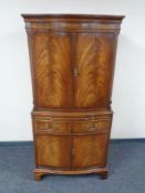 A 20th century mahogany double door cocktail cabinet fitted a slide,