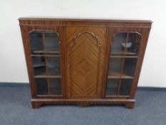 An early 20th century mahogany triple door bookcase with central panel door and glass doors either