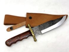 A Bowie knife with engraved blade and brass cross guard,