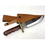 A Bowie knife with engraved blade and brass cross guard,