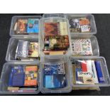 A pallet containing nine plastic storage boxes with lids containing books,