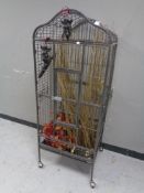 A large metal bird cage on castors containing dried flowers