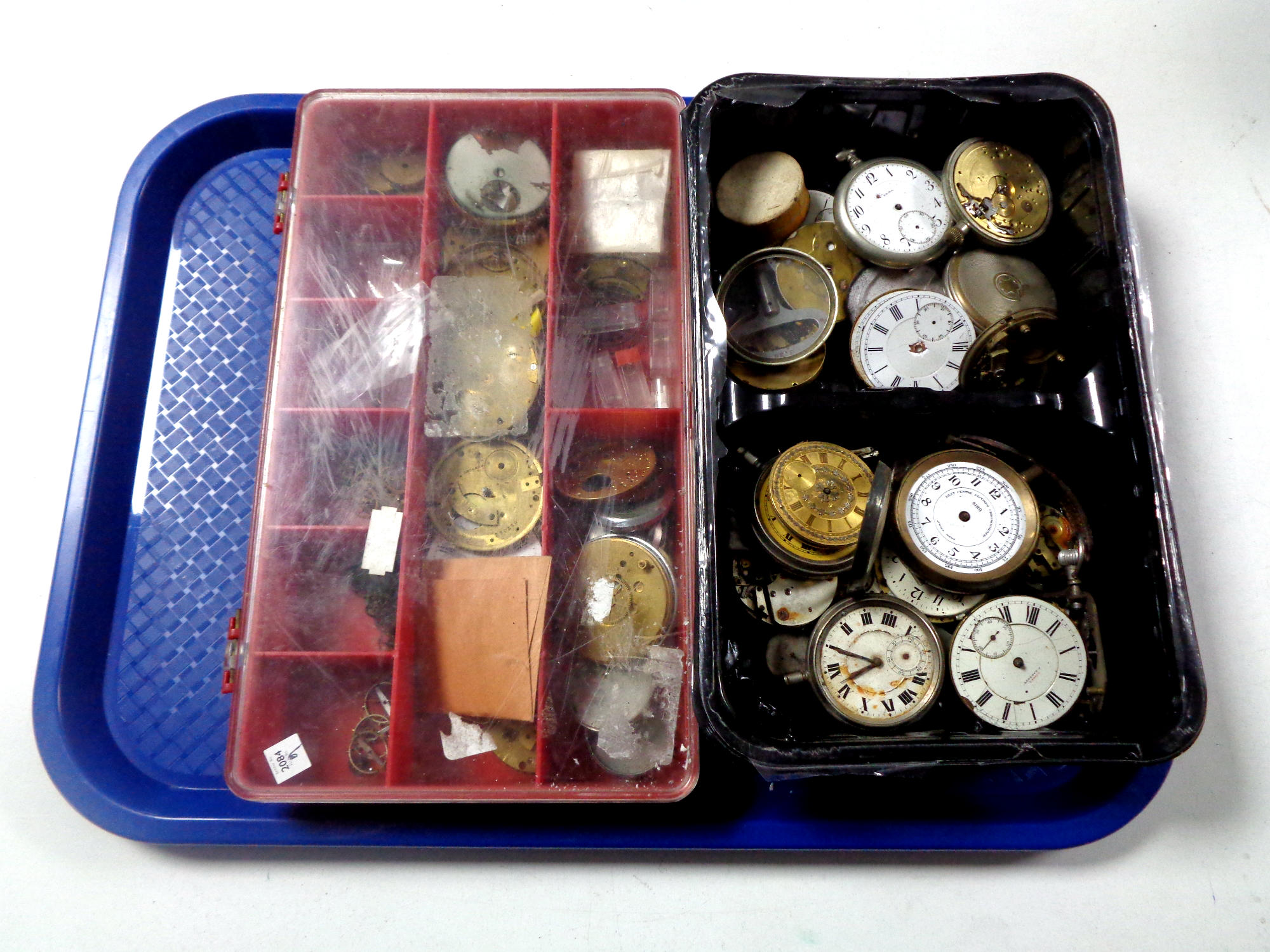 A tray containing horologist's pocket watch parts
