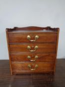 An Edwardian four drawer counter top collector's chest with brass drop handles