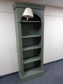 A set of painted contemporary open bookshelves fitted with a lamp