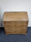 A Georgian oak writing bureau fitted four drawers with brass drop handles