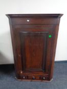 A George III hanging oak corner cupboard