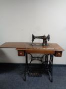 A 20th century Singer treadle sewing machine in oak table