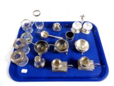 A tray containing five assorted silver rimmed vases, bottles and salts,