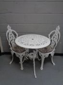 A painted cast metal circular patio table and two chairs CONDITION REPORT: Table-