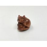 A carved Chinese hardwood netsuke - Rat on fruit