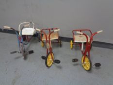 A mid 20th century toddler's Raleigh tin plate tricycle together with two other similar tricycles