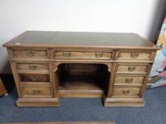 A 19th century oak twin pedestal desk fitted nine drawers with a green tooled leather inset panel