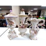 A three piece glazed pottery flower encrusted set to include lidded vase,