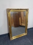 A decorative gilt framed bevel edged overmantel mirror