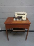 A mid 20th century Singer sewing machine in table