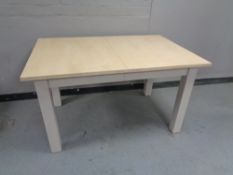 A contemporary extending dining table on painted legs