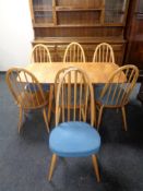 An Ercol solid elm and beech drop leaf kitchen table and seven high back chairs