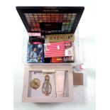 A tray containing assorted cosmetics, perfumes,