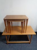 A nest of three teak tables by Russell of Broadway and a further teak coffee table