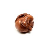 A carved Chinese hardwood netsuke - Two rats on fruit