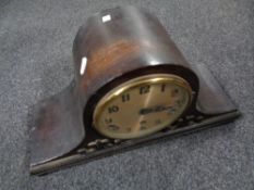 A 1930s oak cased mantel clock with silver dial.