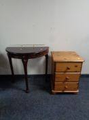 A pine three drawer bedside chest together with a demi lune table in a mahogany finish