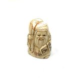 A carved Chinese bone netsuke - Village elder holding a sack